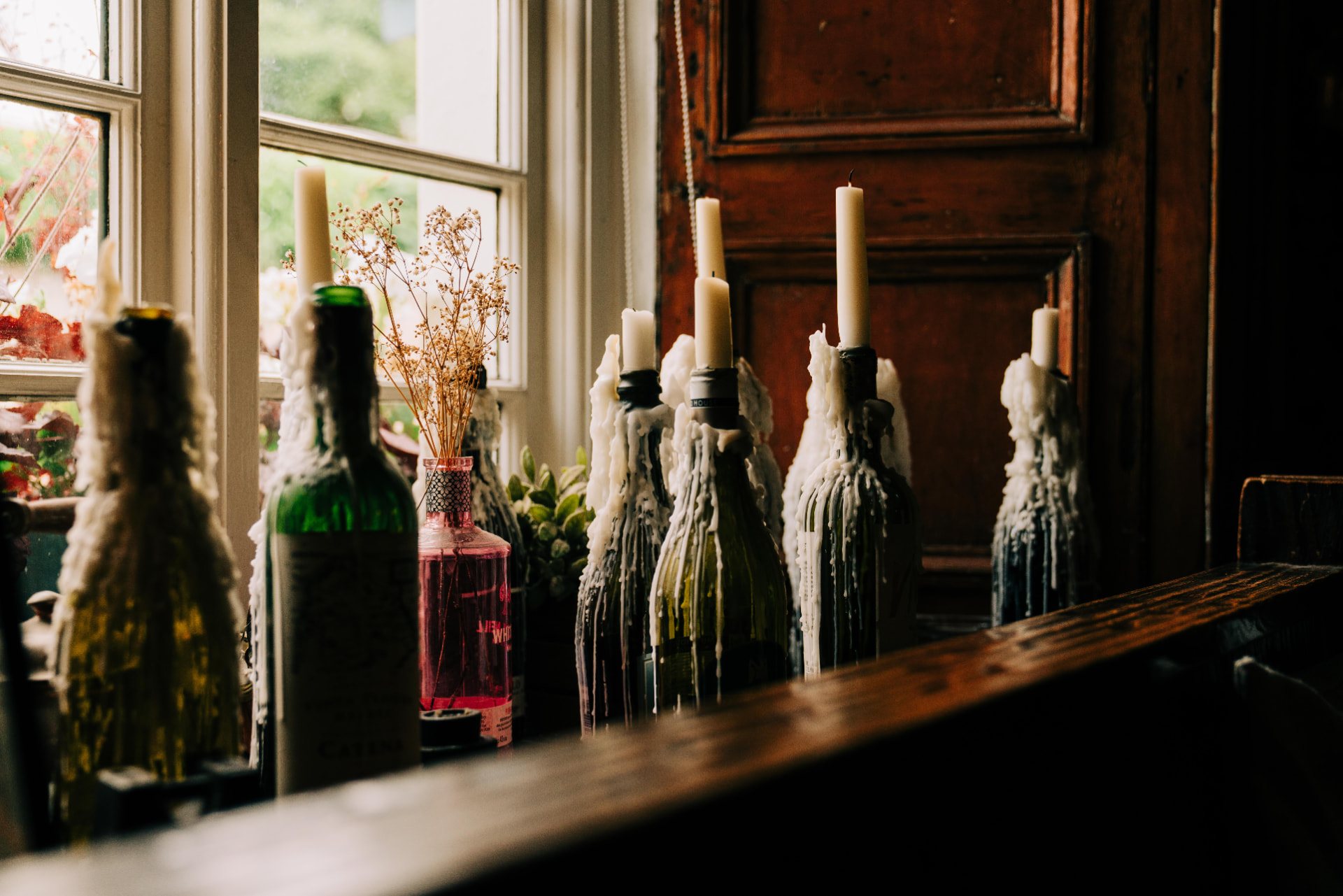 Candle bottles along a window ledge