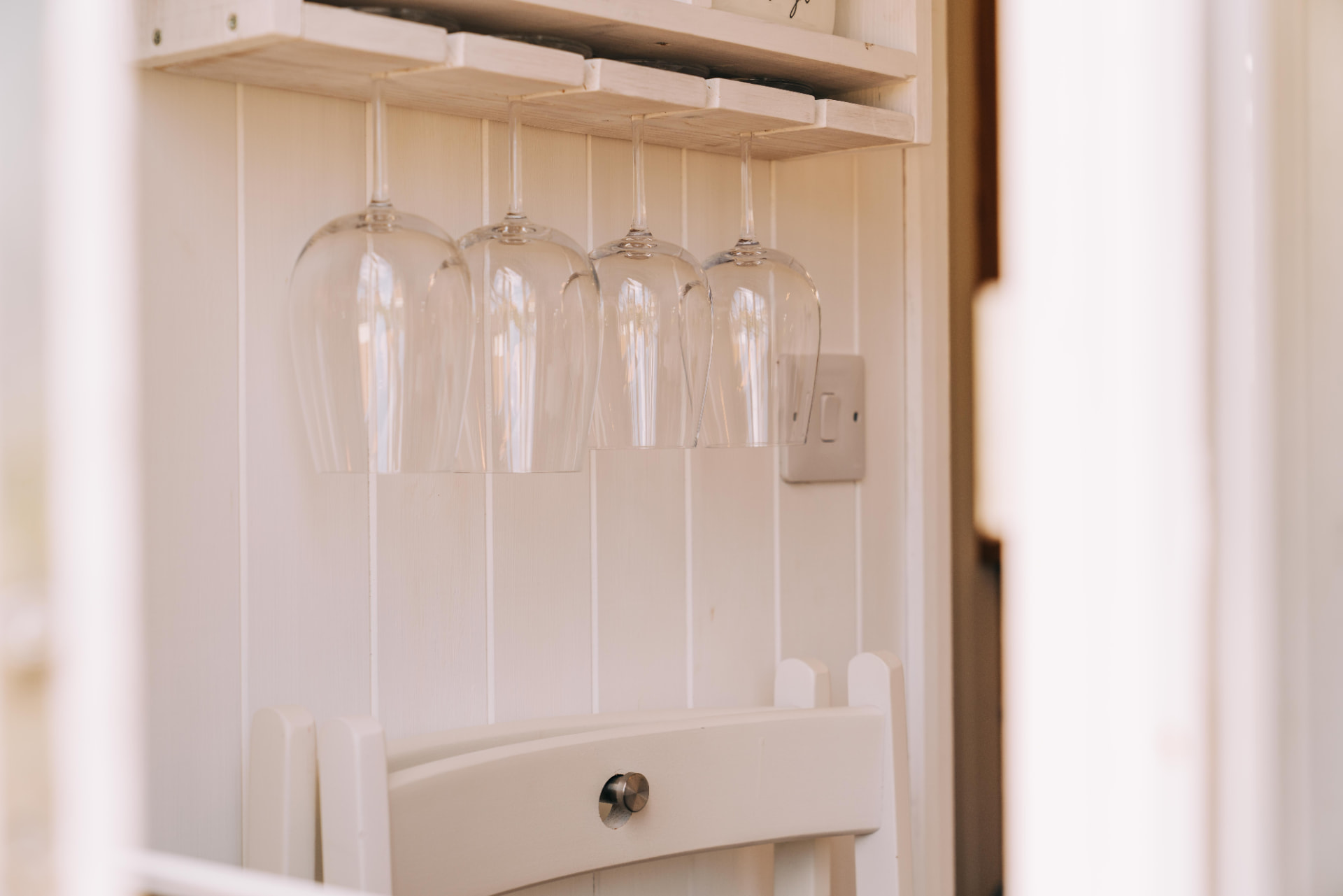 Wine glasses hanging above a folding chair