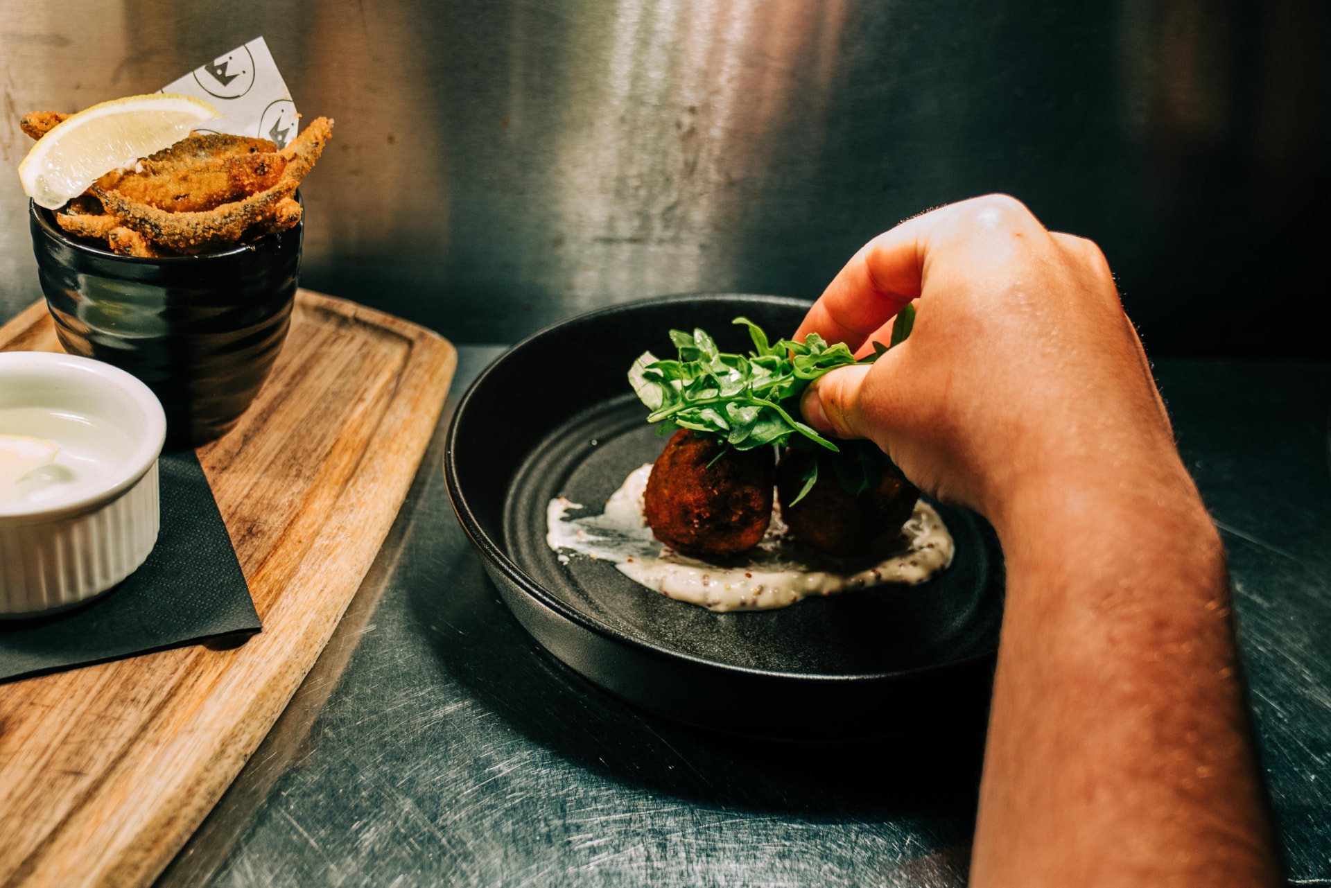 A dish being garnished at the pass