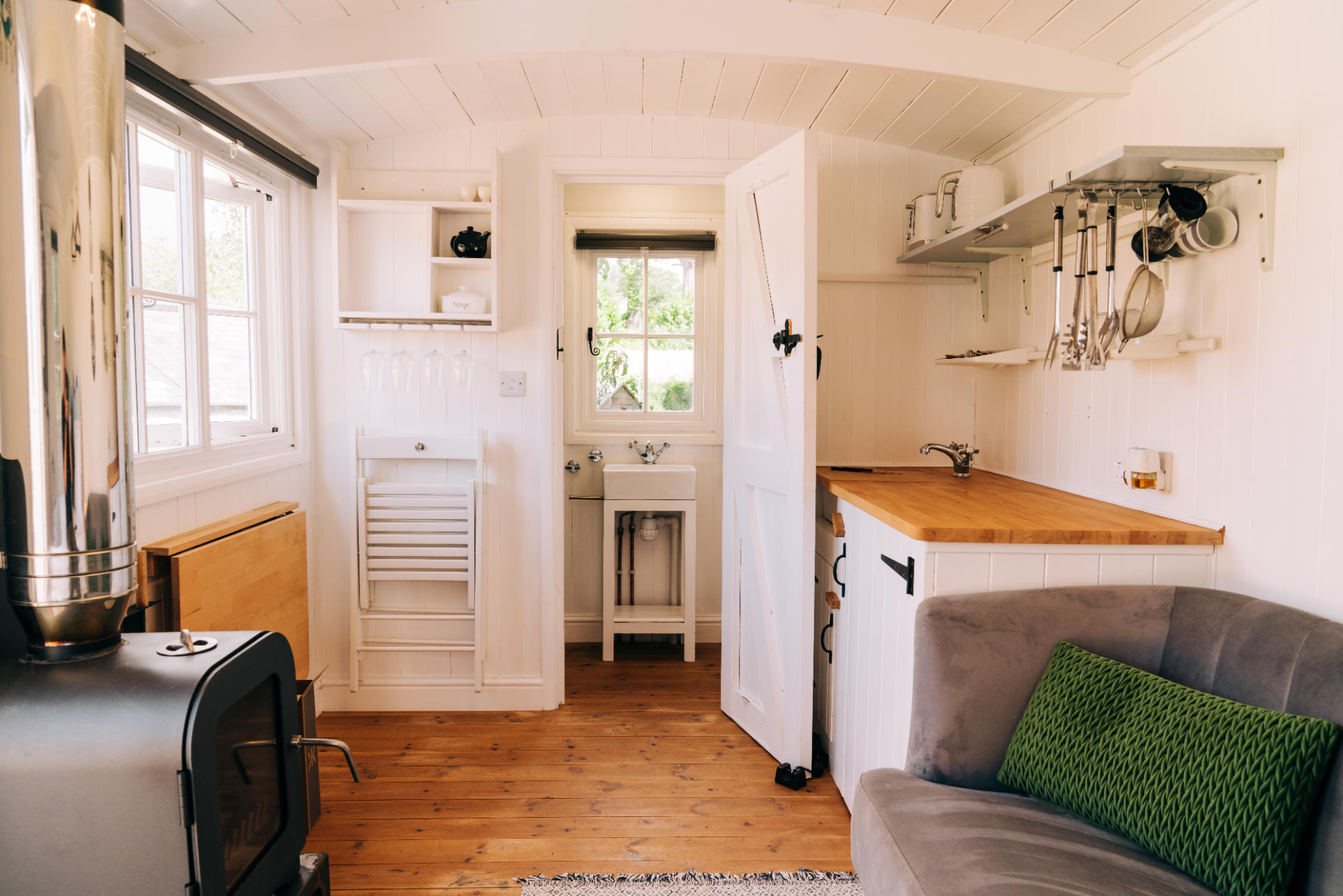 Kitchenette with wooden worktop and the shower room beyond