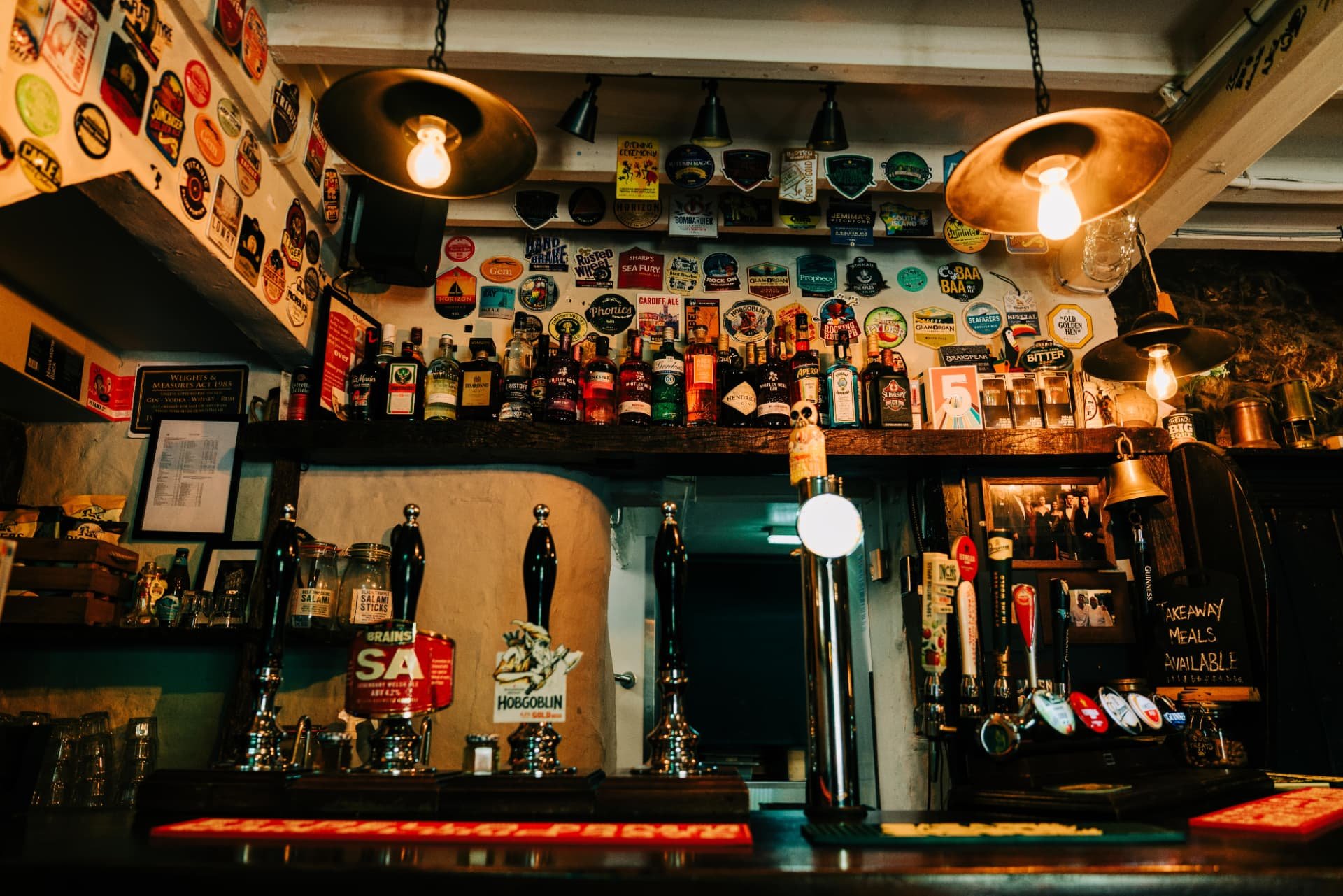 The bar with its hand pulls, lamps and beer mats covering the ceiling