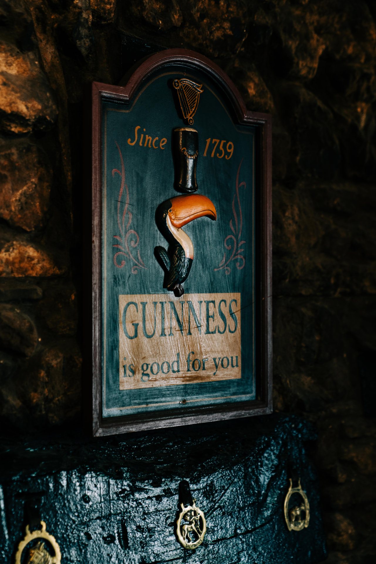 A vintage Guinness toucan sign on the stone wall