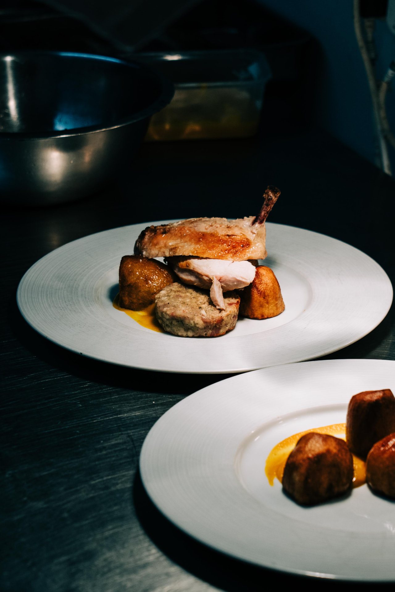 Plated main courses waiting at the pass