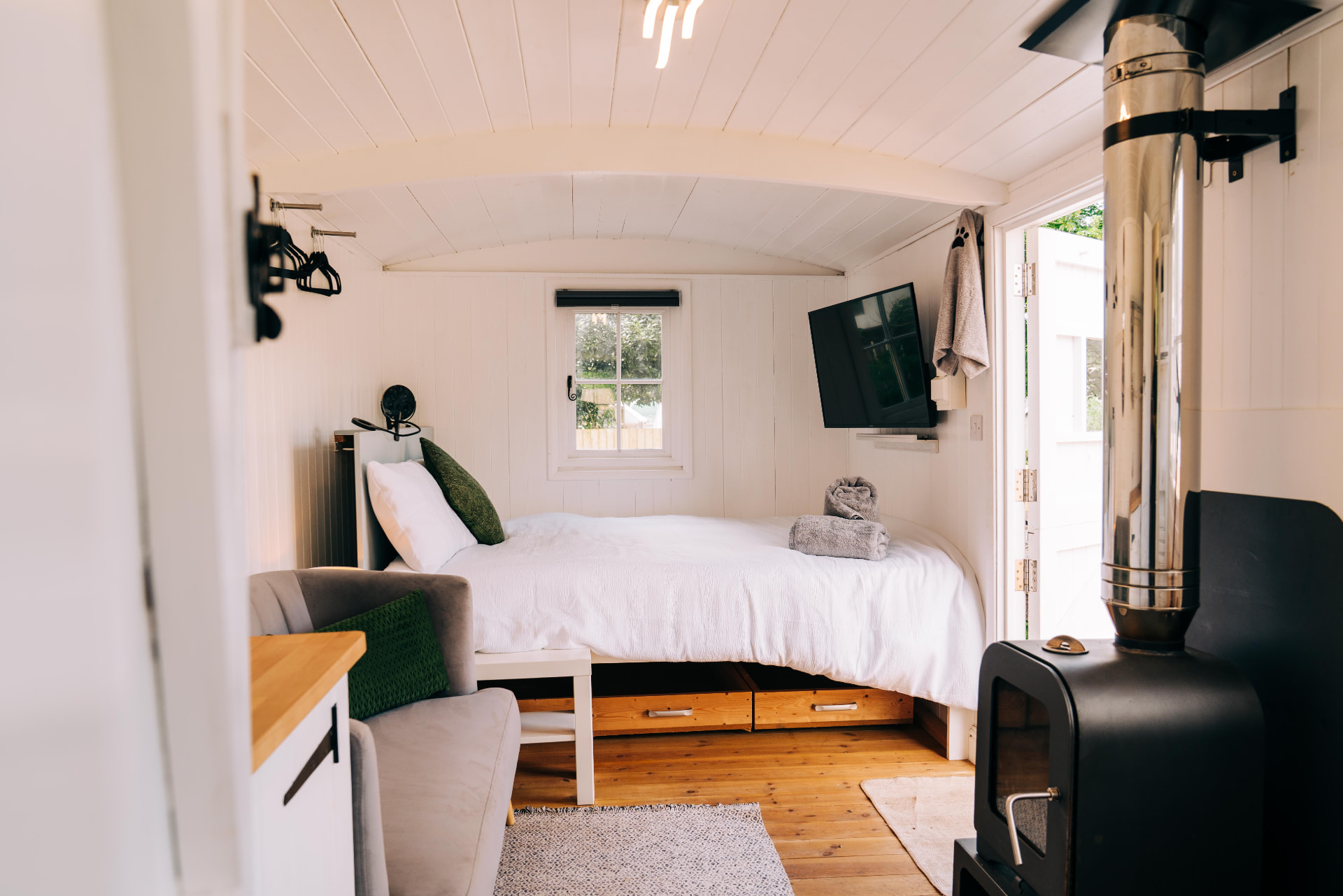 Double bed at the end of the hut with the log burner in front